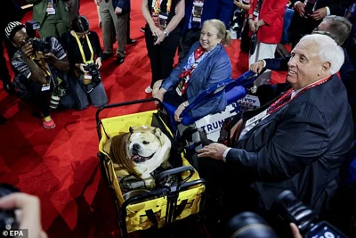 Republican West Virginia Governor Governor Jim Justice (R) attends with his dog Babydog Justice (L) looks on during the second day of the Republican National Convention (RNC) in Milwaukee, Wisconsin