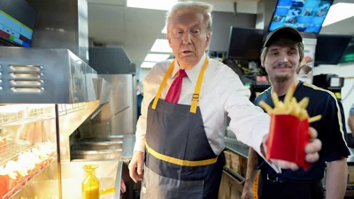 Donald Trump hands off an order of fries after working alongside an employee during a visit to McDonald's in Feasterville-Trevose, PA, 20 October 2024