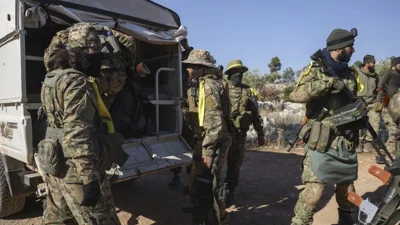 Syrian opposition fighters get off a truck as they enter the village of Anjara, western outskirts of Aleppo, Syria, Thursday Nov. 28, 2024, part of their major offensive on go