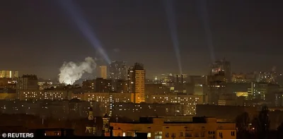 Ukrainian service personnel use searchlights as they search for drones in the sky over the city during a Russian drone strike, amid Russia's attack on Ukraine, in Kyiv