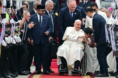 Pope Francis (center) is welcomed during his arrival at Soekarno–Hatta International Airport in Jakarta on September 3, 2024. AFP PHOTO