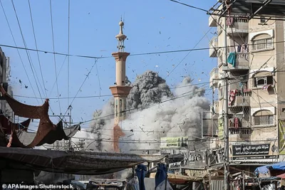 Palestinians watch smoke rising during an Israeli airstrike on the Al Farouq Mosque in the Al Nuseirat refugee camp, central Gaza Strip, 23 November 2024