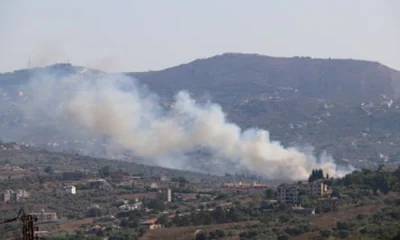 Smoke rises from a hillside