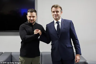 Volodymyr Zelensky was pictured clasping hands with France's president Emmanuel Macron today