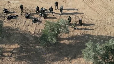 Some soldiers can be seen running around the kibbutz during the Hamas attack