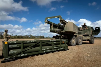 A US soldier prepares the crane for loading the ATACMS on the HIMARS in Queensland, Australia