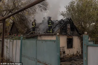 Ukrainian firefighters try to extinguish the fire in a house following an air attack in a village outside of Kostyantynivka, in the eastern Donetsk region, on October 16