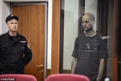 Wall Street Journal reporter Evan Gershkovich stands listening to the verdict in a glass cage of a courtroom inside the building of "Palace of justice," in Yekaterinburg, Russia, on Friday, July 19, 2024