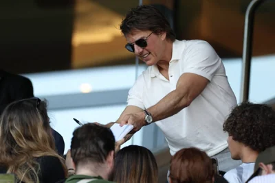 US actor Tom Cruise signs autographs as he attends the women's gold medal final football match between Brazil and US during the Paris 2024 Olympic Games at the Parc des Princes in Paris on August 10, 2024. AFP PHOTO