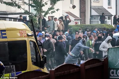 Rioters wearing masks launch missiles towards police officers in Southport