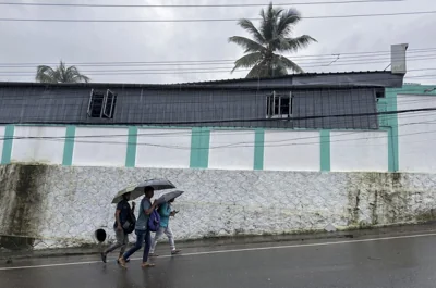 People leave for work in the morning holding umbrellas during a rain in Kochi, Kerala state, India, Tuesday, July 30, 2024.