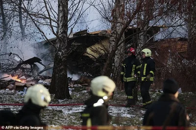 Lithuanian rescuers are seen working next to the wreckage of a cargo plane following its crash near the Vilnius International Airport in the country's capital this morning