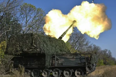 A Ukrainian brigade firing a howitzer on the front line in eastern Ukraine. There is fire and smoke coming from the barrel