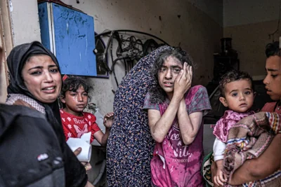 A woman and children react following Israeli bombardment in Nuseirat in the central Gaza Strip