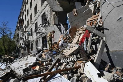 A rescuer and a service dog inspect the debris at the site of a destroyed residential building following an aerial bomb in the centre of Kharkiv, Ukraine, June 22. AFP-Yonhap