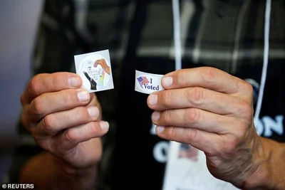 n election worker shows "I Voted" stickers, during the 2024 U.S. presidential election on Election Day, in Arden, North Carolina