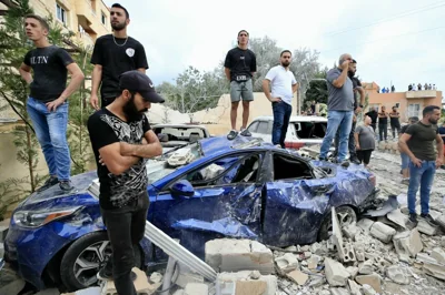 People inspect the damage at the site of an Israeli airstrike that targeted an apartment building in town of Barja south of Beirut on October 12, 2024. AFP PHOTO 