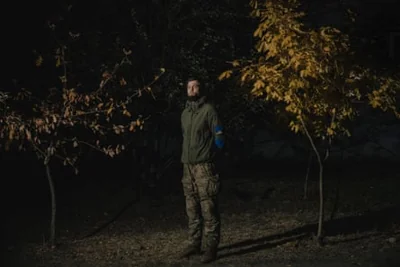 Vitaliy Ovcharenko standing in darkness next to some trees