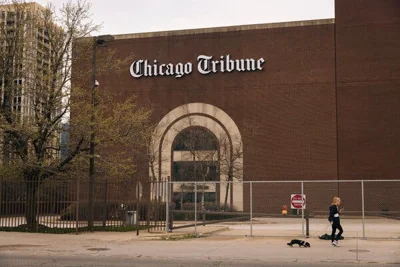 A brick facade with an arched entrance bears a Chicago Tribune sign.