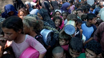 Palestinians line up for food distribution in Deir el-Balah, Gaza