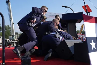 Trump, seen here being swarmed by Secret Service agents, recovered from his wounds and appeared at the Republican National Convention two days later