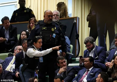 Security personnel talk to attendees as Israel's Prime Minister Benjamin Netanyahu addresses the United Nations