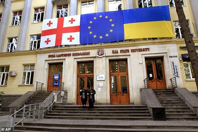 From left: Georgian national, EU and Ukrainian national flags hangs at a polling station during the parliamentary election in Tbilisi, Georgia, Saturday, October 26, 2024