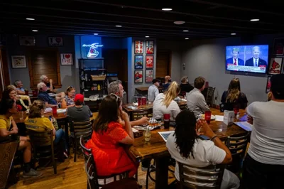 Patrons look on during a watch party of the presidential debate between President Joe Biden and Republican presidential candidate former President Donald Trump at Old Louisville Tavern, June 27, in Louisville, Ky. AP-Yonhap