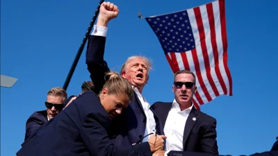 Republican presidential candidate former President Donald Trump is surrounded by U.S. Secret Service agents after an assassination attempt at a campaign rally in Butler, Pa., Saturday, July 13, 2024.