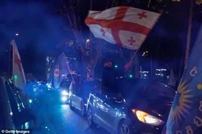 Georgian Dream Party supporters celebrate the exit poll results outside the new Georgian Dream headquarters during Georgian Election Day on October 26, 2024 in Tbilisi, Georgia