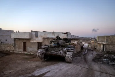 A destroyed Syrian army tank sits in the village of Anjara, western outskirts of Aleppo