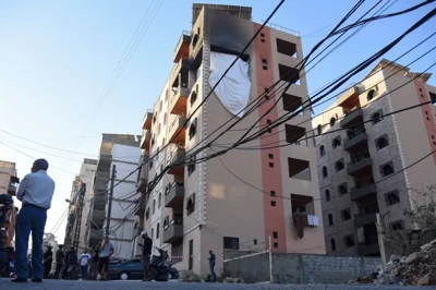 People stand at the site hit by an Israeli strike that, according to a security source, killed Saeed Atallah, a leader in Hamas' armed wing al-Qassam brigades, with three family members, in the northern city of Tripoli, Lebanon October 5, 2024. REUTERS/Omar Ibrahim