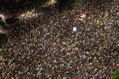 an aerial view of a street filled with protestors at night