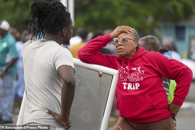 Sylvia Small, right, waits for police approval to enter the pier to check her boat's damages due to Hurricane Beryl at the Bridgetown Fisheries in Barbados, Monday, July 1, 2024