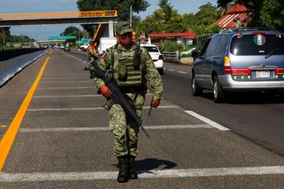 a Mexican soldier patrols near a checkpoint