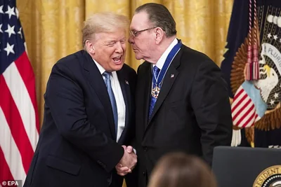 Donald J. Trump (L) shakes hands with retired US General Jack Keane (R) after awarding him the Presidential Medal of Freedom in Washington, March 10, 2020