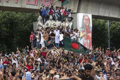 Protesters climb a public monument as they celebrate the news of Prime Minister Sheikh Hasina's resignation, in Dhaka, Bangladesh, Monday, Aug. 5, 2024.