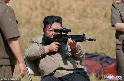 North Korean leader Kim Jong Un aims a weapon as he visits the training base of the special operations armed force of North Korea's army at an undisclosed location in North Korea