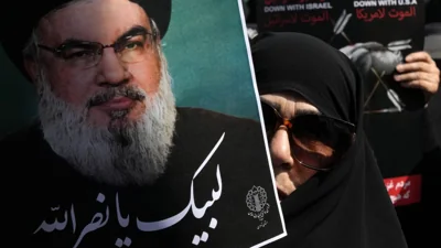 An Iranian worshipper holds up a poster of Hezbollah leader Sayyed Hassan Nasrallah, September 27th 2024