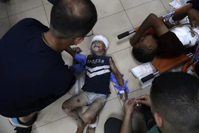 Palestinian medics treat a child wounded in an Israeli bombardment on a residential apartment in central Gaza, June 14, 2024