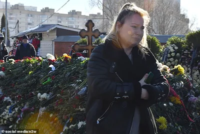 People stand in long queues, waiting for their turn to lay flowers and bid farewell to Navalny two days after he was buried