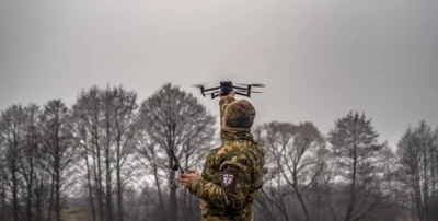 военный ВСУ держит FPV-дрон в руке