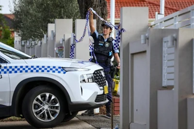 A police officer lifts tape to let a car into the Christ the Good Shepherd Church in Sydney's western suburb of Wakeley on April 16, 2024. Australian police on April 16 said a brutal knife attack during a live-streamed church service was a religiously motivated 'terrorist' act, as they urged calm from the angered local community. (Photo by DAVID GRAY / AFP)