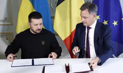 Volodymyr Zelenskiy and Alexander De Croo signing documents