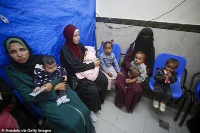 Palestinians wait in line at a United Nations Relief and Works Agency (UNRWA) clinic in Deir al-Balah today to receive medication and medical treatment as Israel's attacks on Gaza continue