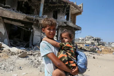 A Palestinian boy holds a girl as they flee the eastern part of Khan Younis