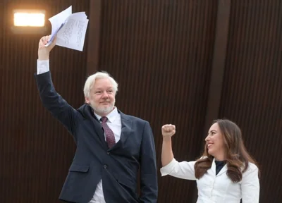 The Wikileaks founder and his wife, Stella Assange, raised their arms Tuesday as they arrived.