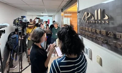 Journalists listen to Gold Apollo founder and chief executive Hsu Ching-kuan at the door of the company’s office in New Taipei City.