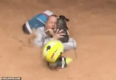 Rescuers attempt to evacuate a woman and her dog from their flooded house