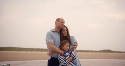 Princess Charlotte hugs their parents as they look out over a beach in Norfolk